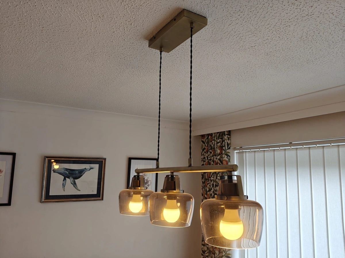 Three light pendant fitted over a dining area