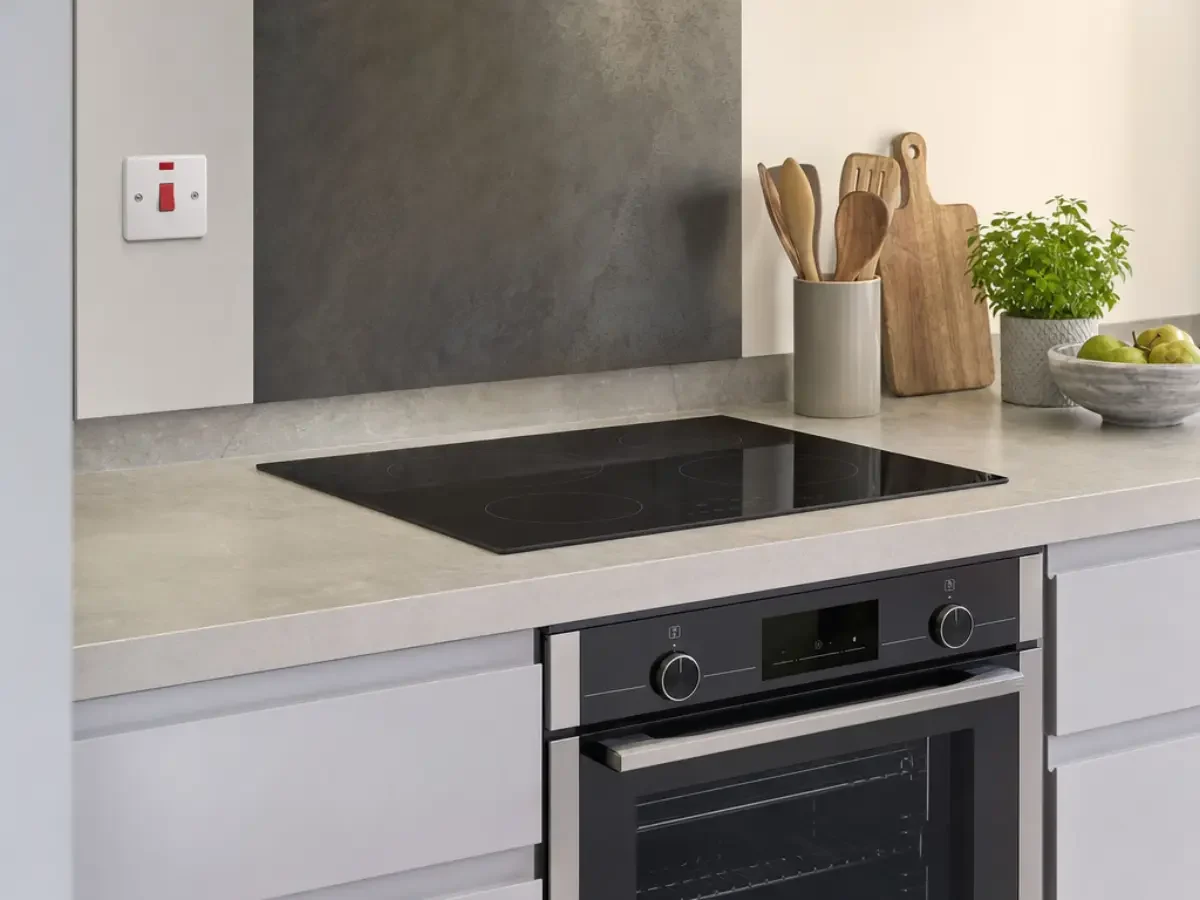 Illustration of an electric induction hob and oven beside a cooker isolator by Re-energize Electrical